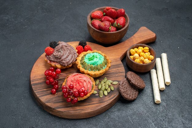 Vorderansicht köstliche cremige Kuchen mit Früchten auf dunklem Hintergrund