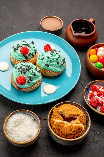 Vorderansicht köstliche cremige Kuchen mit Süßigkeiten auf dunklem Hintergrund Süßigkeiten Keks Kuchen Dessert Keks Farbe dessert