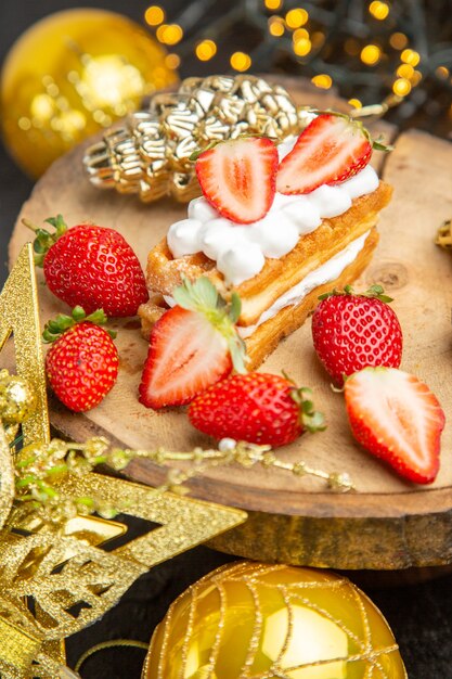 Vorderansicht köstliche cremige Kuchen um Feiertagsbaumspielzeug auf dunklem Hintergrund Dessertkuchen süße Fotocreme