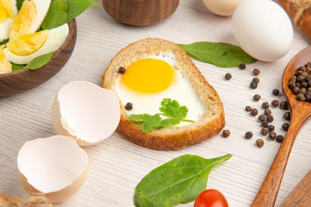 Vorderansicht köstliche Eiertoasts mit Tomaten und Gewürzen auf weißem Hintergrund Foto Morgen Mahlzeit Frühstück Mittagessen Salat Farbe Lebensmittel