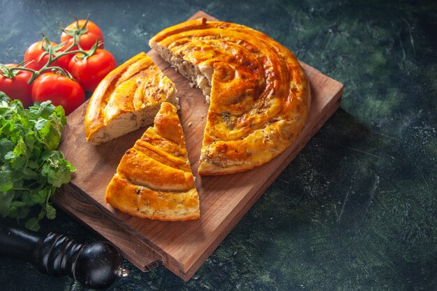 Vorderansicht köstliche Fleischpastete mit roten Tomaten und Grüns auf dunklem Hintergrund Kuchen Essen backen Teig Kuchen Gebäck Keksofen