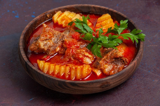 Vorderansicht köstliche Fleischsaucensuppe mit Grüns und in Scheiben geschnittenen Kartoffeln auf dunkler Oberflächensaucensuppe Mahlzeit Essen Abendessen Gericht