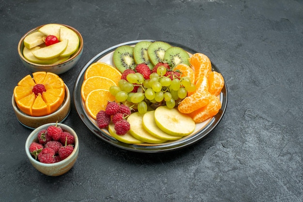 Kostenloses Foto vorderansicht köstliche fruchtzusammensetzung frische und geschnittene früchte auf dunklem hintergrund gesundheit reife frische früchte weich