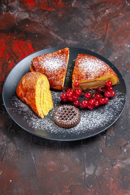 Vorderansicht köstliche geschnittene Torte mit roten Beeren auf dem dunklen Tisch