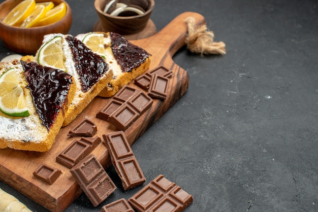 Vorderansicht köstliche Kuchenstücke mit Schokolade auf dunklem Hintergrund