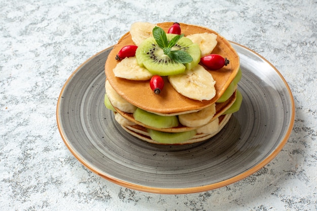 Vorderansicht köstliche Pfannkuchen mit geschnittenen Früchten im Teller