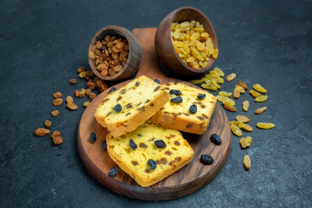 Vorderansicht köstliche Rosinenkuchen geschnitten mit frischen Rosinen auf dunkelblauem Raum