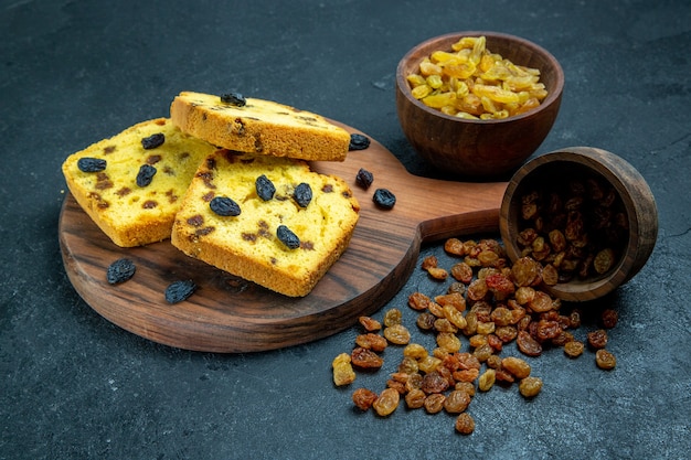 Vorderansicht köstliche Rosinenkuchen geschnitten mit frischen Rosinen auf dunkelblauem Raum