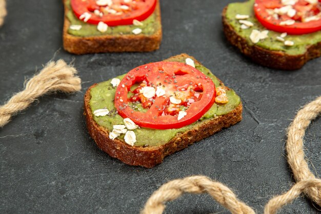 Vorderansicht köstliche Sandwiches mit Wassabi und roten Tomaten auf dem grauen Hintergrund Brot Burger Sandwich Mahlzeit Snack