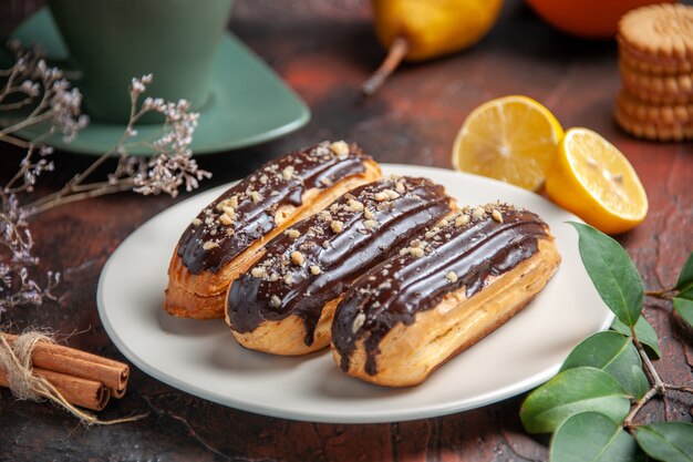 Vorderansicht köstliche Schoko-Eclairs auf dem dunklen Hintergrund