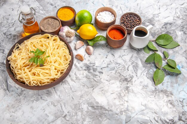 Vorderansicht köstliche Spaghetti mit Gewürzen auf hellweißem Nudelteig