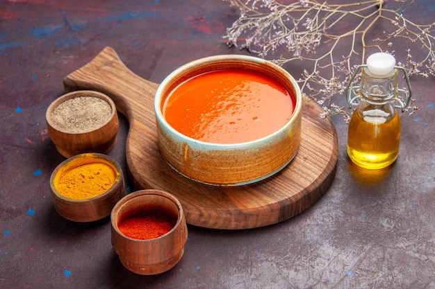 Kostenloses Foto vorderansicht köstliche tomatensuppe mit gewürzen auf dunklem raum