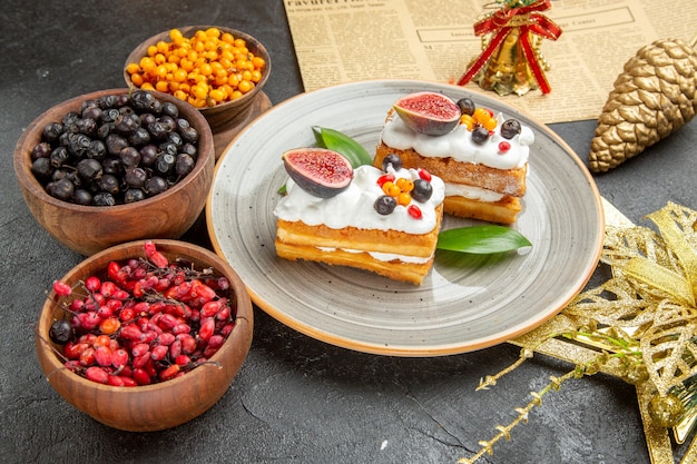 Vorderansicht köstliche Waffelkuchen mit Früchten auf dunklem Hintergrund süßer Kuchen Fotocreme Dessert