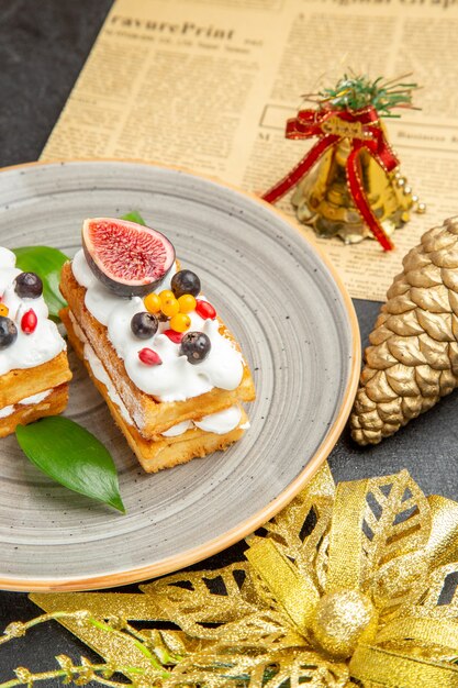 Vorderansicht köstliche Waffelkuchen mit Früchten auf einem grauen Hintergrund süßer Kuchencreme-Dessert