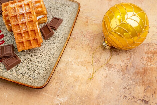 Vorderansicht köstliche Waffelkuchen mit Neujahrsbaumspielzeug auf hellem Hintergrund süßer Kuchencreme-Dessertkuchen