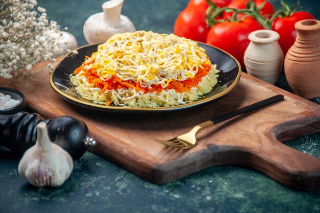 Vorderansicht köstlichen Mimosensalat innerhalb Platte mit Tomaten auf dunkelblauer Oberfläche Feiertagsmahlzeit Farbe Küche Essen Geburtstag Fleisch Küche Foto