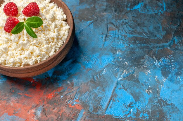 Vorderansicht köstlicher Hüttenkäse mit frischen Himbeeren auf blauem Hintergrund Gesundheit weißes Foto Fruchtfarbe Milch