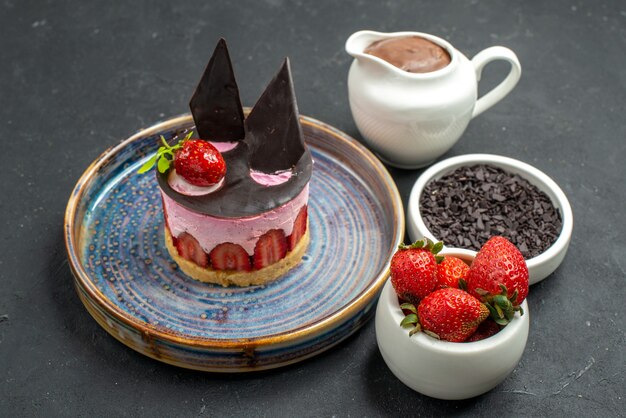 Vorderansicht köstlicher Käsekuchen mit Erdbeeren und Schokolade auf Tellerschalen mit Schokoladenerdbeeren