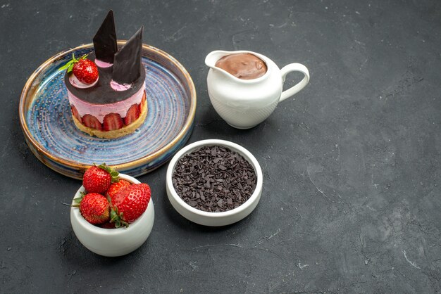 Vorderansicht köstlicher käsekuchen mit erdbeeren und schokolade auf tellerschalen mit schokoladenerdbeeren