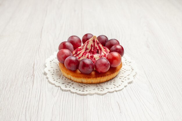 Vorderansicht köstlicher Kuchen mit Trauben auf weißem Hintergrund