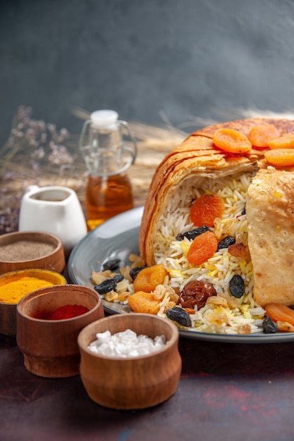 Vorderansicht köstlicher shakh plov mit Rosinen und Gewürzen auf einem dunklen Raum