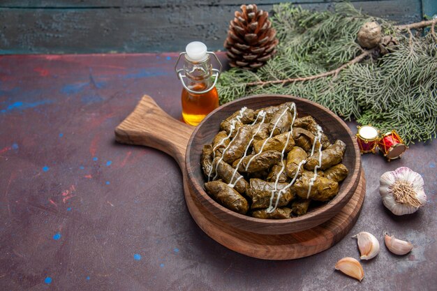 Vorderansicht köstliches Blatt-Dolma-Fleischgericht mit Gewürzen auf dunklem Raum