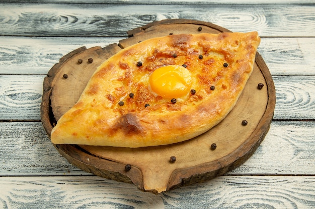 Vorderansicht köstliches Eierbrot, das auf einem rustikalen grauen Raum gebacken wird