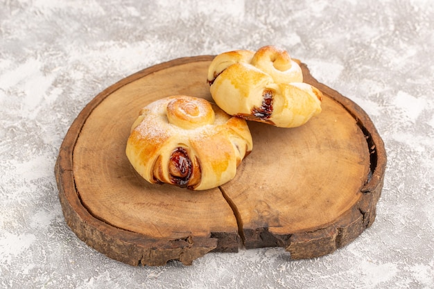 Vorderansicht köstliches fruchtiges Gebäck süß gebacken auf dem grau-hellen Wandkuchen Gebäck backen Tee