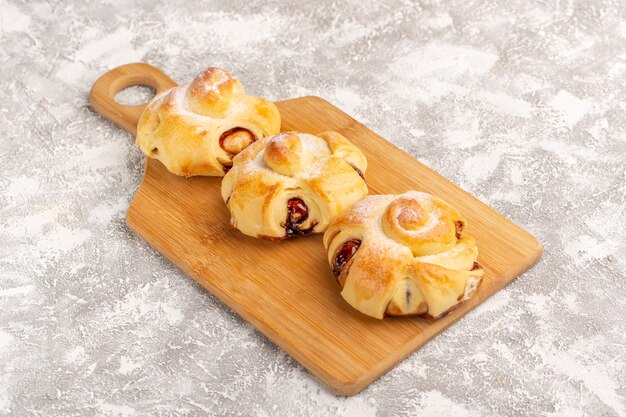 Vorderansicht köstliches fruchtiges Gebäck süß gebacken auf der grauen Oberfläche Kuchen Gebäck süßer Tee