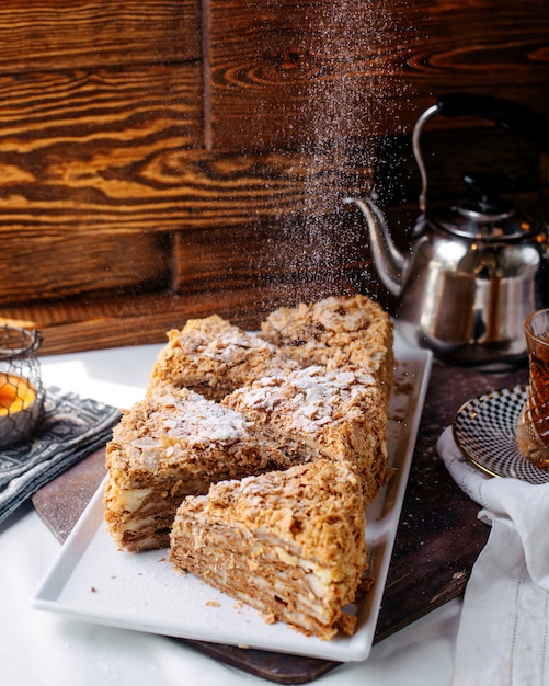 Vorderansicht Kuchenscheiben lecker lecker in weißen Platte auf der hellen Oberfläche