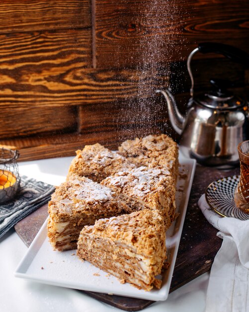 Vorderansicht Kuchenscheiben lecker lecker in weißen Platte auf der hellen Oberfläche