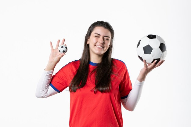 Vorderansicht lächelnde junge Frau in Sportkleidung mit Fußball