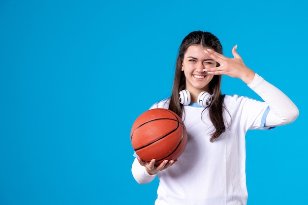 Kostenloses Foto vorderansicht lächelnde junge frau mit basketball