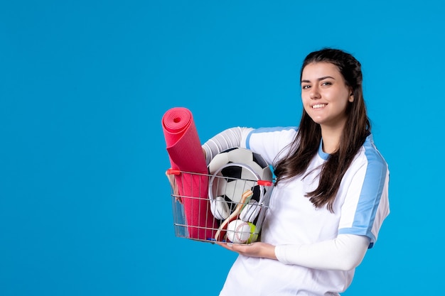 Vorderansicht lächelnde junge Frau mit Korb nach Sporteinkauf