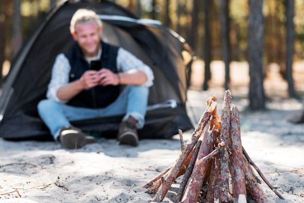 Kostenloses Foto vorderansicht lagerfeuer holz und verschwommener mann