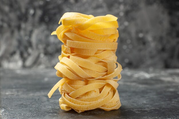 Vorderansicht lange Teigstücke auf grauem Hintergrund gerollt Teig Mahlzeit Essen Pasta Dunkelheit Küche