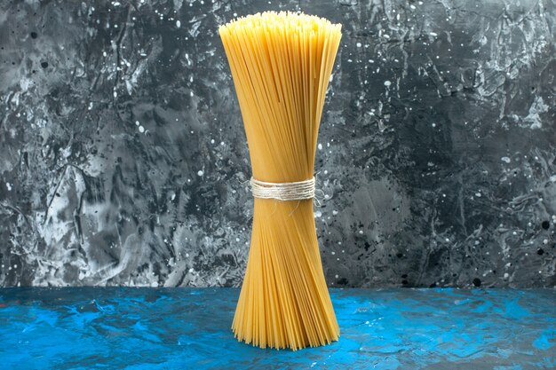 Vorderansicht langes italienisches Pasta-Rohprodukt, das auf Blaulicht-Mahlzeit gebunden ist, viele Lebensmittelteig-Farbfotos