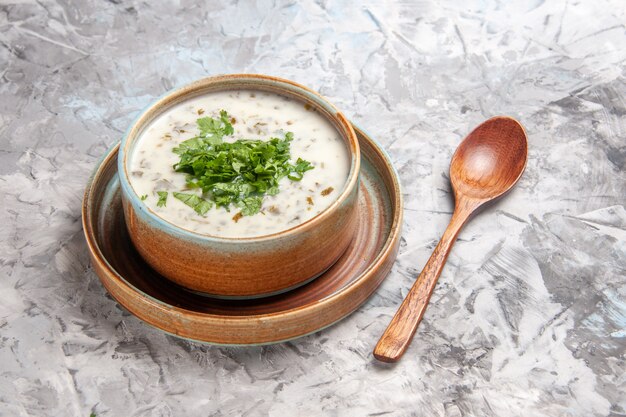 Vorderansicht leckere Dovga-Joghurtsuppe mit Grüns auf weißem Tischmilchsuppengericht