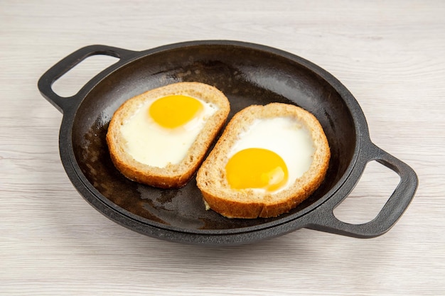 Vorderansicht leckere Ei-Toasts in der Pfanne auf weißem Hintergrund Mahlzeit Ei Frühstück Essen Mittagessen braten Toaster Farbfoto