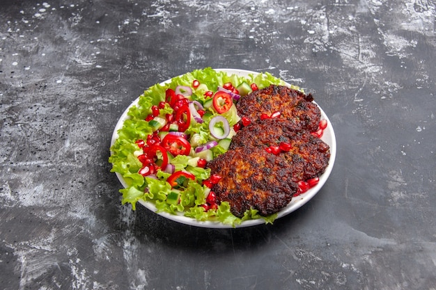 Kostenloses Foto vorderansicht leckere fleischkoteletts mit frischem salat