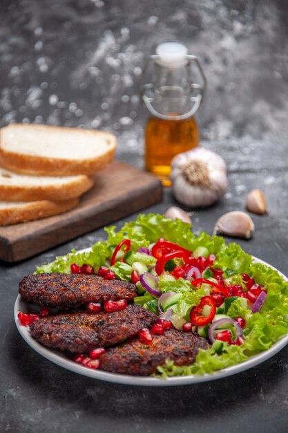 Vorderansicht leckere Fleischkoteletts mit Salat und Brot