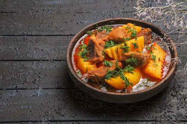 Vorderansicht leckere Fleischsuppe mit Gemüse und Kartoffeln auf dunklem Schreibtisch Fleischsauce Mahlzeit Gericht