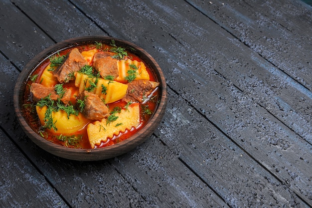 Vorderansicht leckere Fleischsuppe mit Kartoffeln und Gemüse auf dunklem Boden Fleischgericht Sauce Mahlzeit