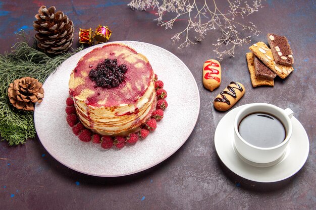 Vorderansicht leckere fruchtige Pfannkuchen mit Tasse Tee auf dunklem Raum
