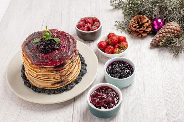 Vorderansicht leckere geleepfannkuchen mit frischen früchten und gelees auf weißem raum