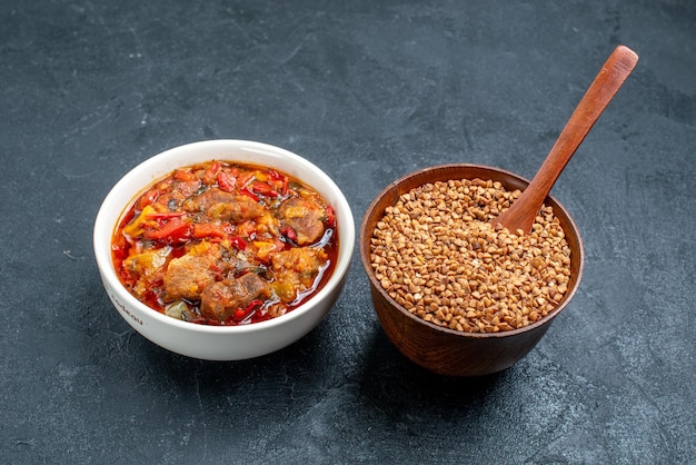 Vorderansicht leckere Gemüsesuppe mit rohem Buchweizen auf dem Grauraum