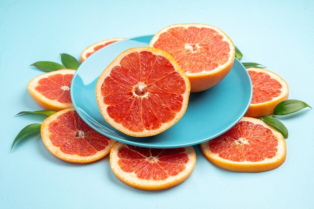 Vorderansicht leckere Grapefruit-Fruchtscheiben auf blauem Tisch