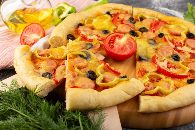Vorderansicht leckere käsige Pizza mit roten Tomaten, schwarzen Oliven und Würstchen auf Dunkelheit
