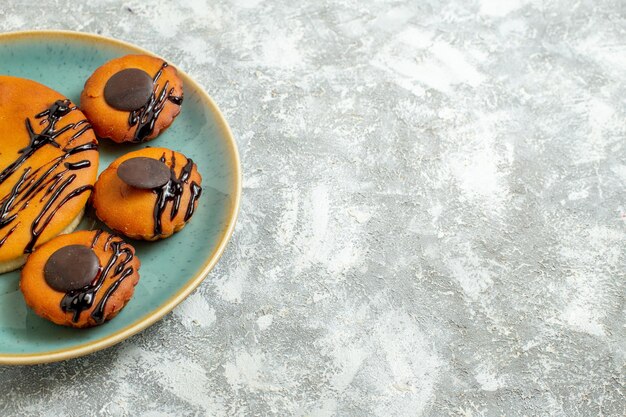 Vorderansicht leckere Kakaokuchen mit Schokoladenglasur im Teller auf weißem Hintergrund süßer Kuchen Keks Dessert Cookie Pies