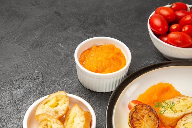 Vorderansicht leckere Kartoffelpasteten mit Kürbis und frischen Tomaten auf grauem Hintergrund backen Abendessen Ofenfarbe reif